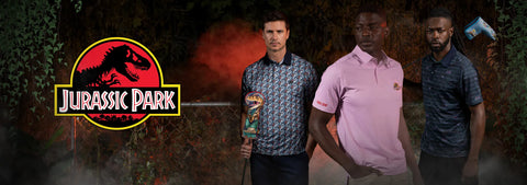 three-men-standing-outdoors-in-dark-foliage-wearing-patterned-and-solid-polo-shirts-with-a-large-jurassic-park-logo-graphic-on-the-left-side-of-the-image