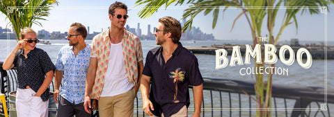four-models-walking-outdoors-by-the-waterfront-wearing-rsvlts-casual-summer-outfits-from-the-bamboo-collection-with-palm-trees-and-a-city-skyline-in-the-background-large-text-on-the-right-reads-the-bamboo-collection