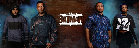 four-models-wearing-various-streetwear-outfits-stand-against-a-dark-brick-wall-backdrop-with-the-absolute-batman-logo-in-the-center