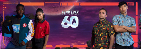 four-people-standing-in-front-of-a-star-trek-60-themed-purple-and-orange-backdrop-wearing-themed-apparel-including-a-star-trek-varsity-jacket-a-red-starfleet-shirt-and-patterned-button-down-shirts