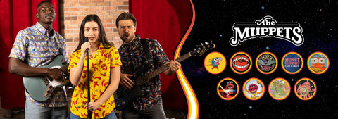 three-people-performing-on-stage-with-the-muppets-logo-and-character-images-in-the-background