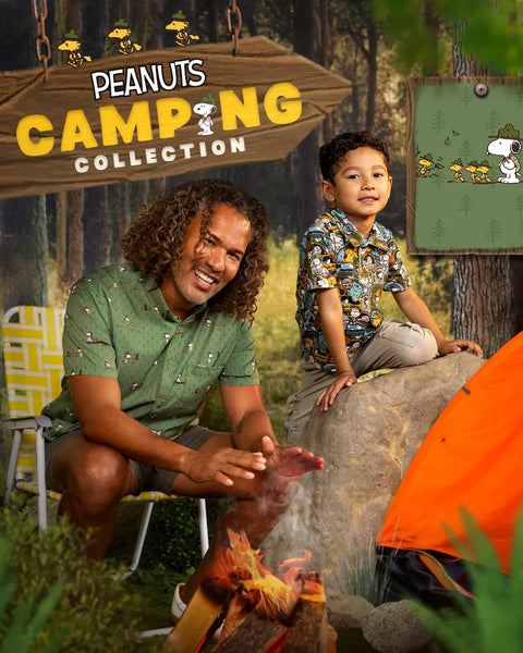 a-man-and-a-child-pose-by-a-campfire-in-a-forest-themed-set-wearing-rsvlts-x-peanuts-shirt-and-polo-with-a-large-wooden-sign-reading-peanuts-camping-collection-and-a-bright-orange-tent-visible-the-scene-appears-to-be-promotional-artwork-for-a-peanuts-camping-themed-product-collection