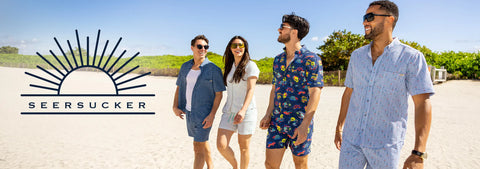 four-people-standing-on-a-beach-wearing-rsvlts-seersucker-shirts-and-shorts-with-the-seersucker-brand-logo