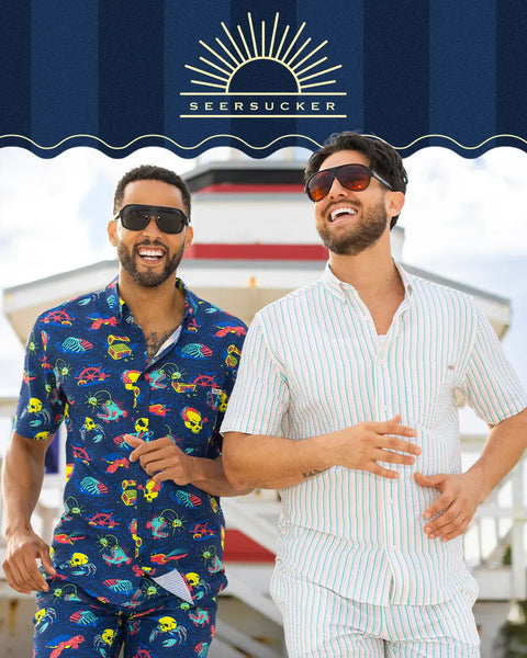 two-men-in-rsvlts-colorful-seersucker-outfits-standing-on-a-boat-with-seersucker-logo-above